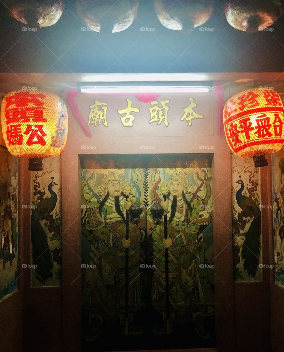 Rice paper lanterns hanging in front of a Temple door in Bangkok in the night 