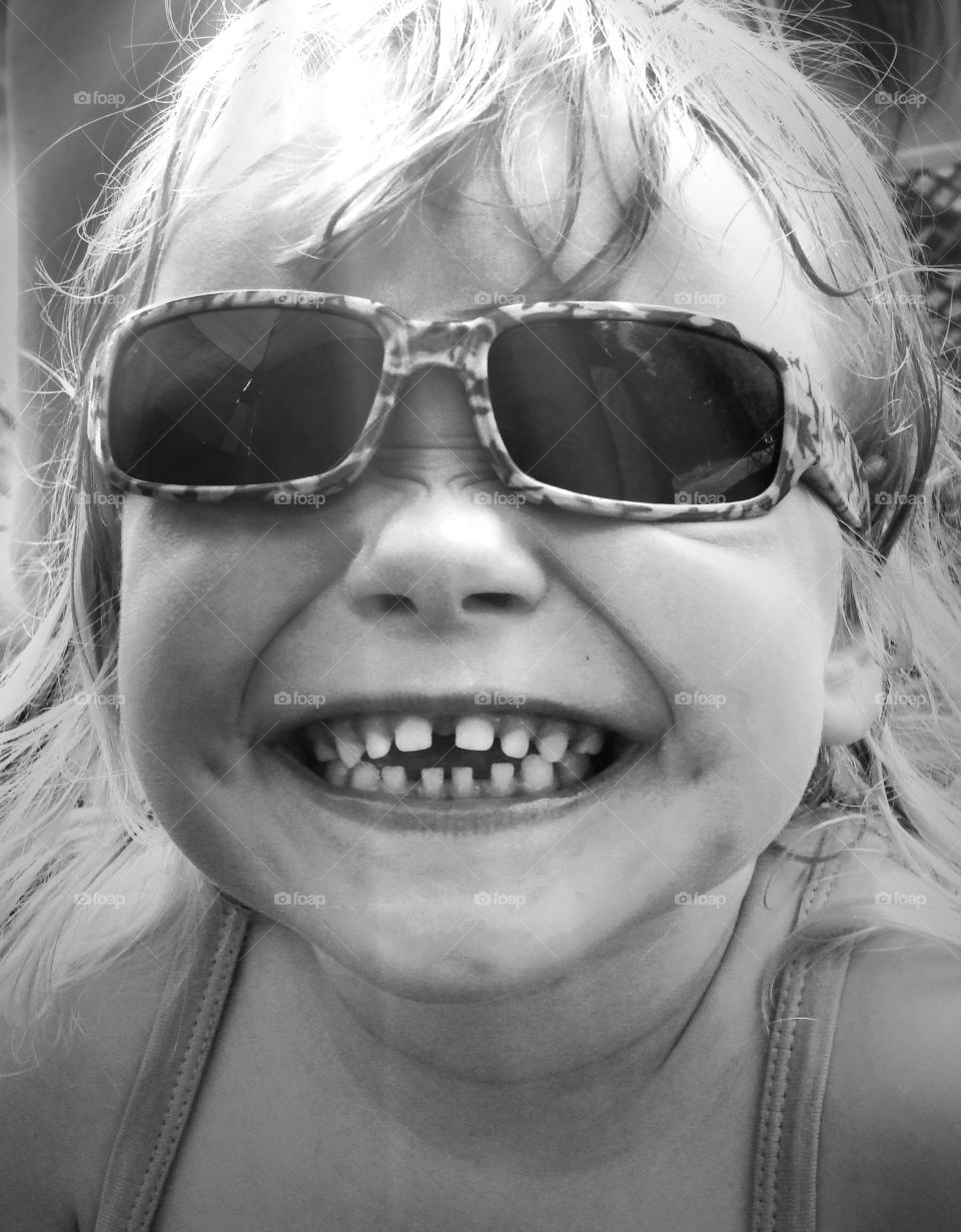 Funny girl. A girl smiling with sunglasses on a hot summer day