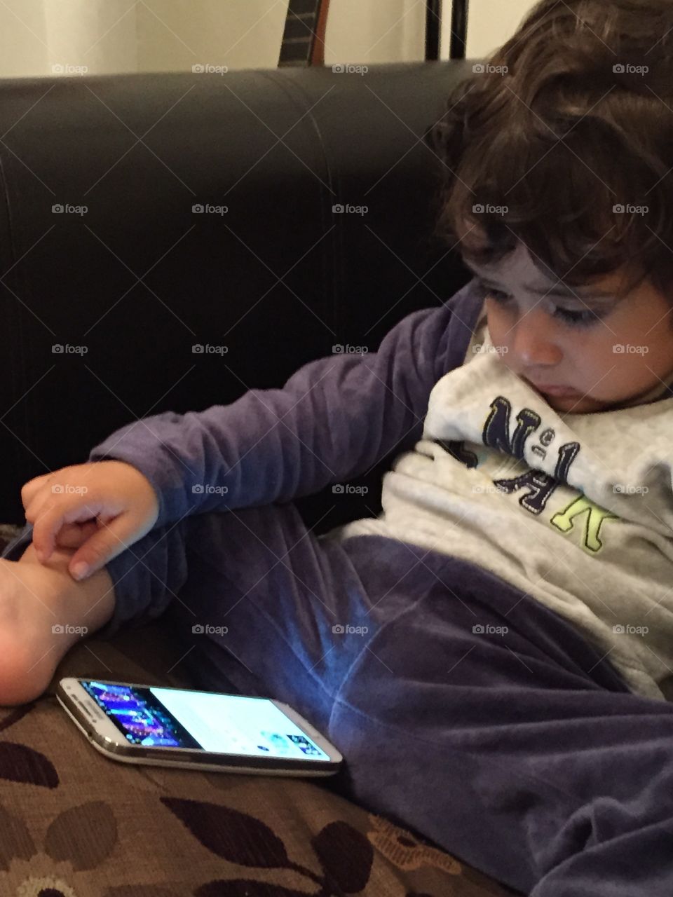 Little boy watching videos on mobile phone