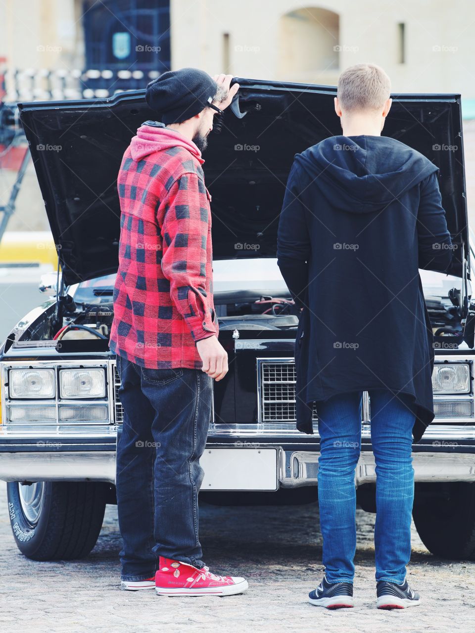 Two men looking under the hood of the retro car
