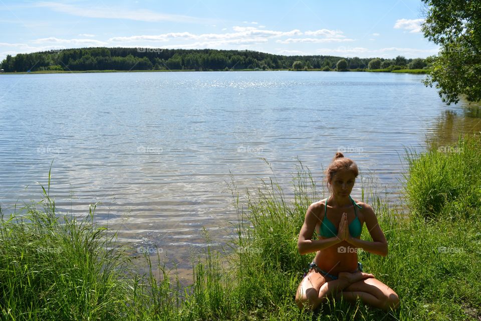 brunette girl in swimsuit training yoga lotus outdoor, summer time