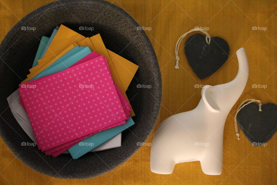 Envelope stack in a basket near an elephant and a heart shaped rock