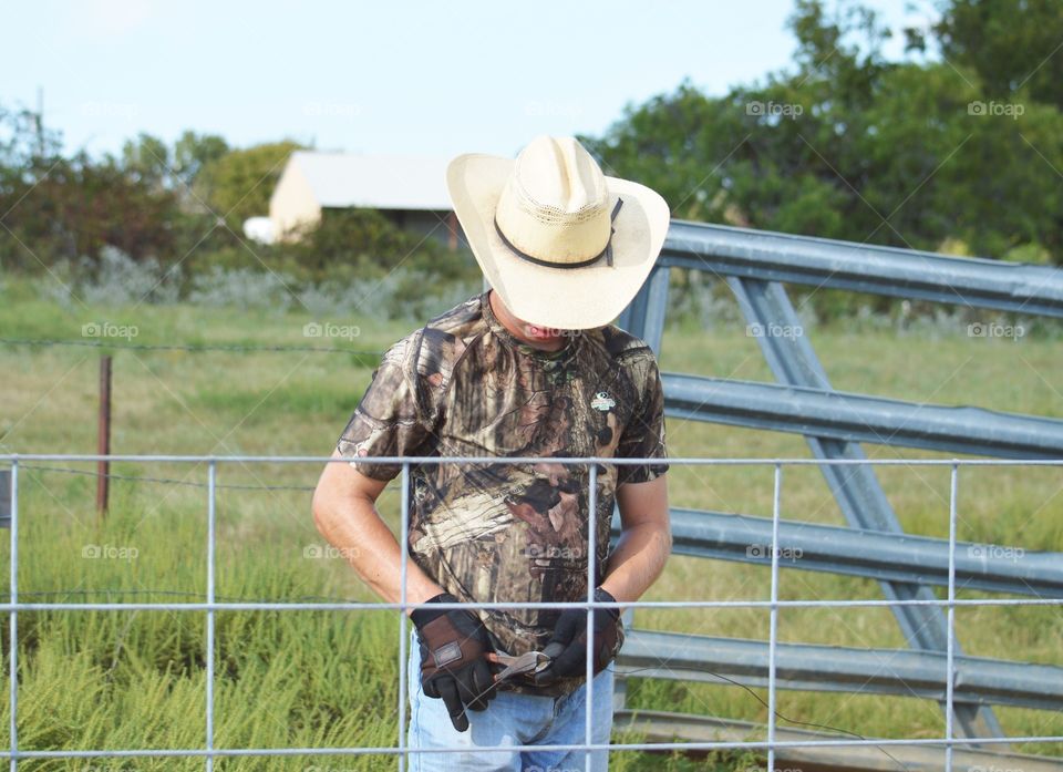 Young Texas cowboy working on sheep pen. 

