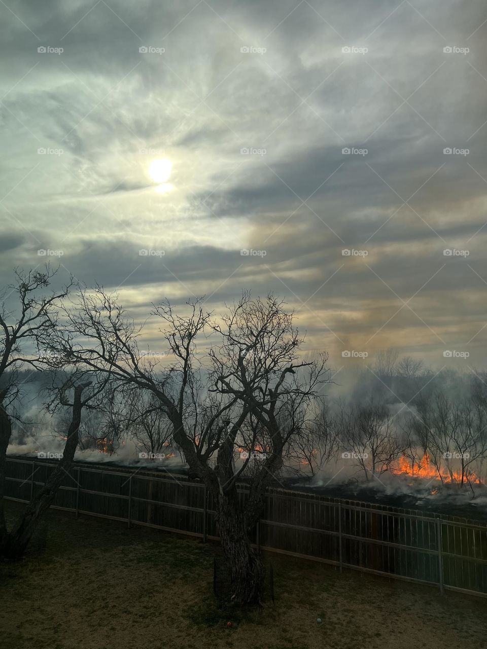 Texas sun shining down on the smoke and flames of controlled burns 