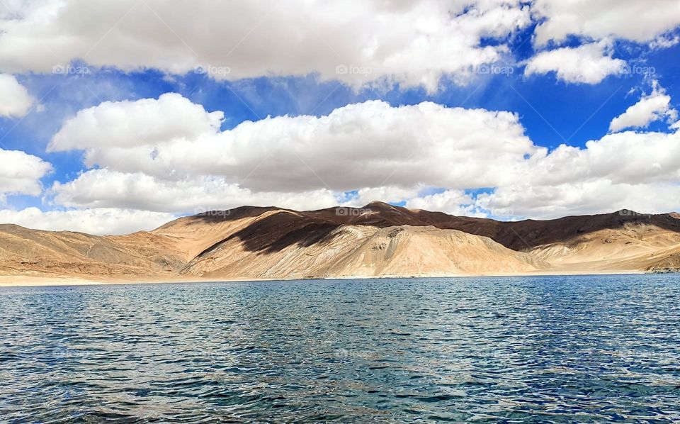 Clouds painting vivid shadows on pinkish orange mountains, amazingly changing every second into a new one but still the same mountain and same shadow. Click of Pangong lake in Ladakh.