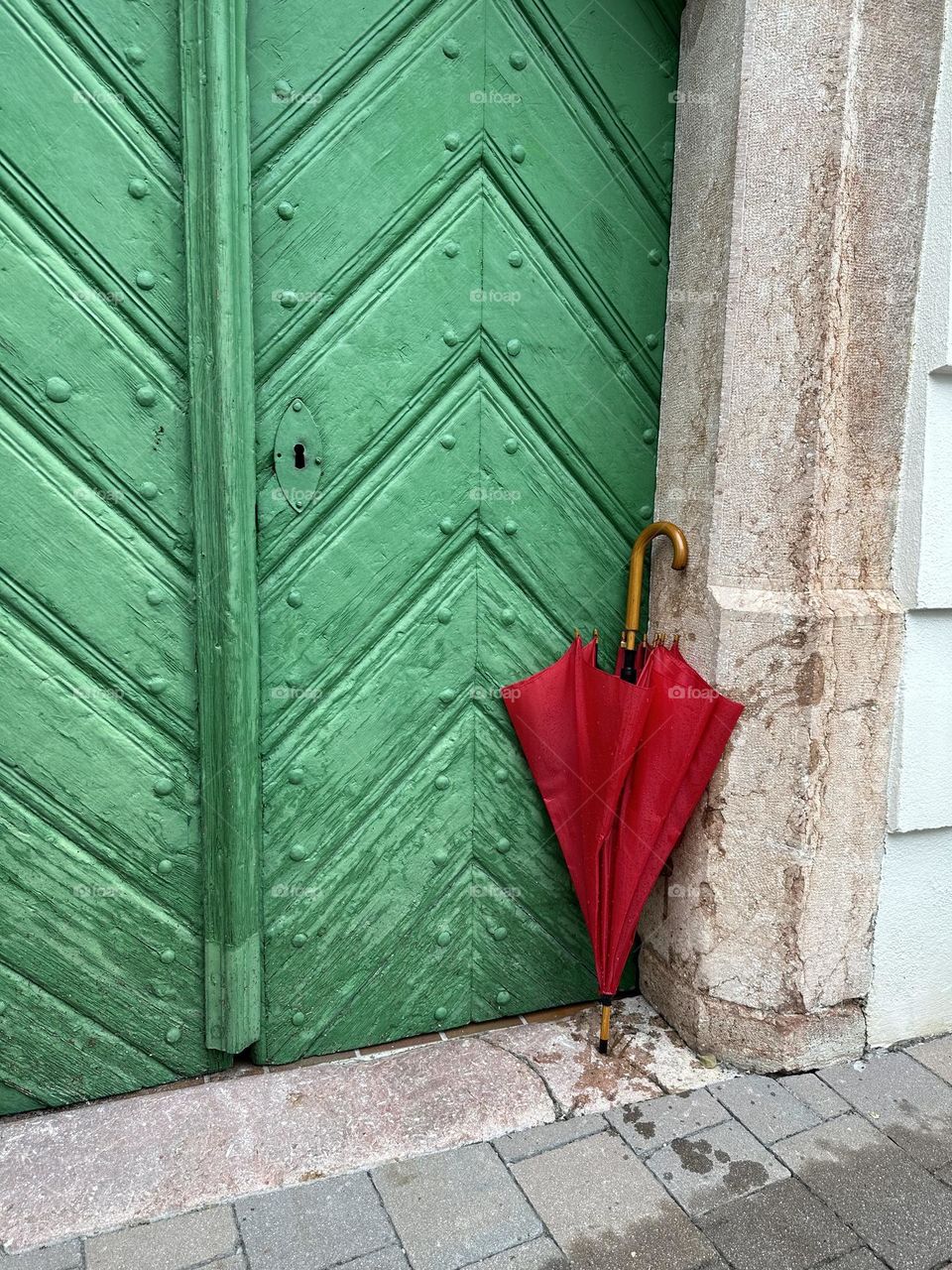 Wet red umbrella by the door 
