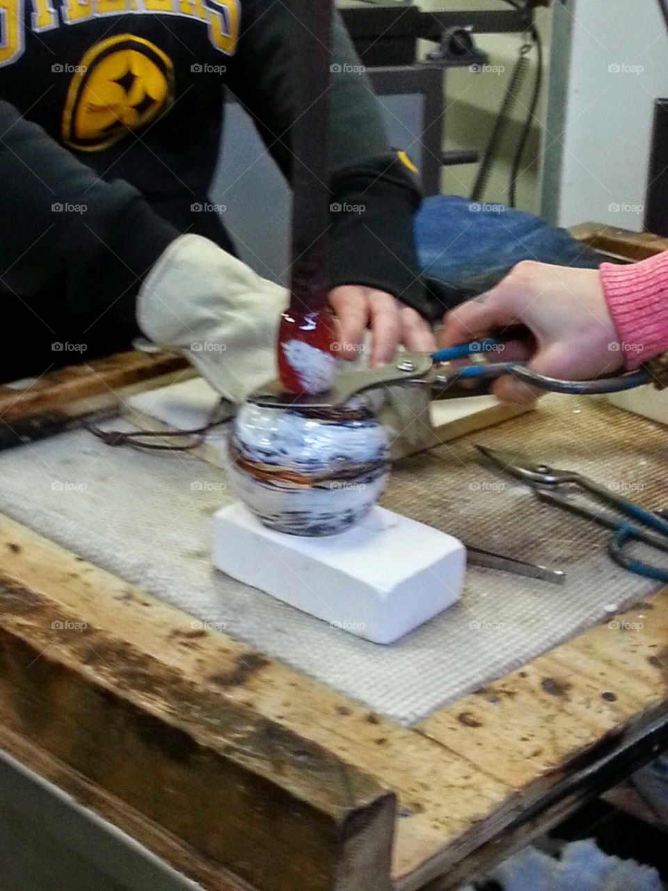 Manipulating molten glass to make a blown glass ornament.