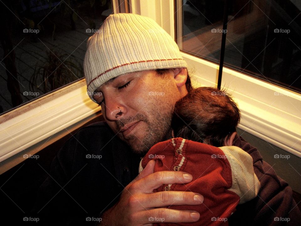 Newborn baby sleeping on father's shoulder