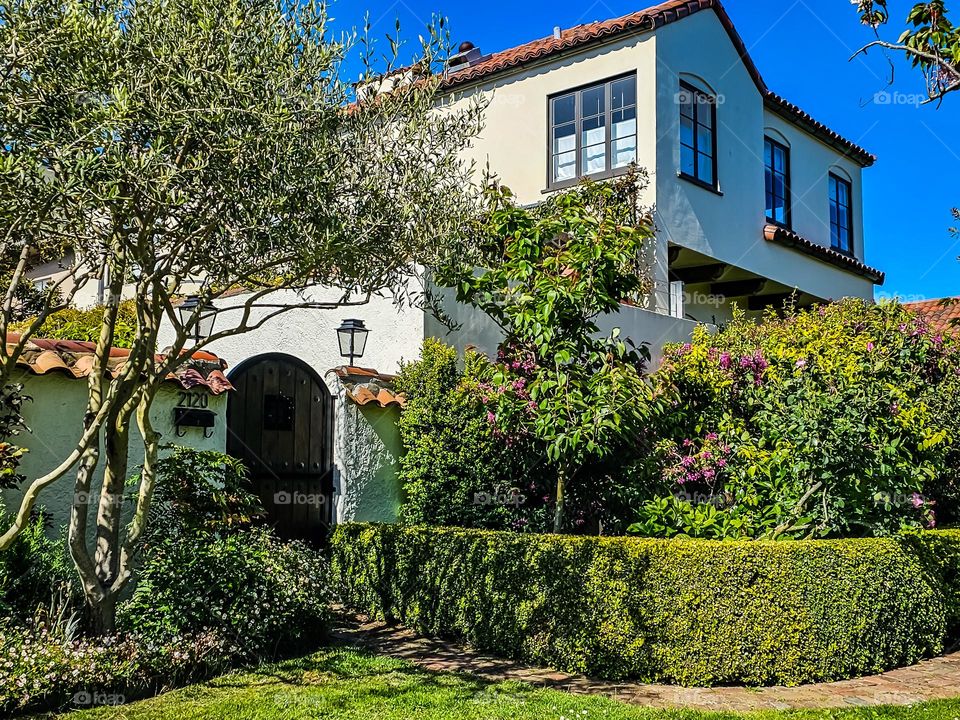 Beautiful garden growing in San Francisco California by the palace of fine arts, flowers in bloom on a warm spring afternoon , and a stunning entrance gate on a beautiful home