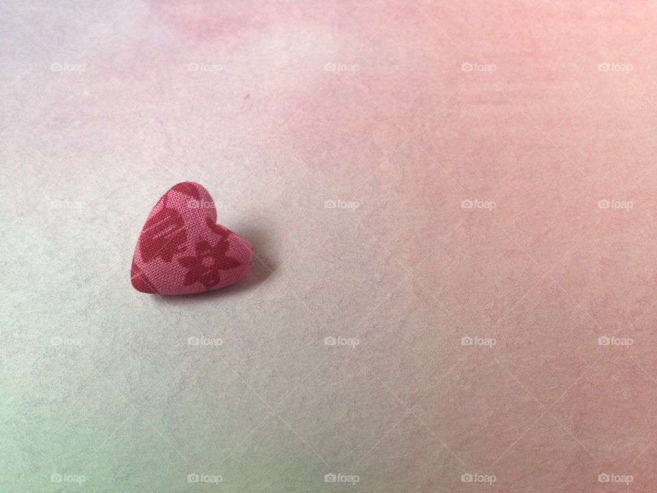 Pink heart button on watercolor background 