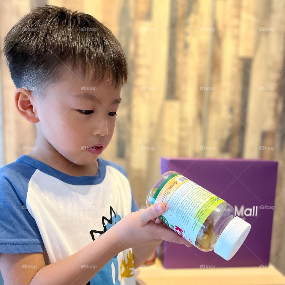 Happy asian kid with multivitamins gummies