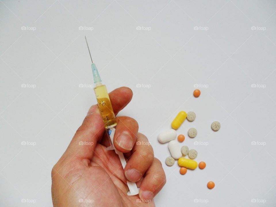 medical syringe, tablets and pills are on a white background