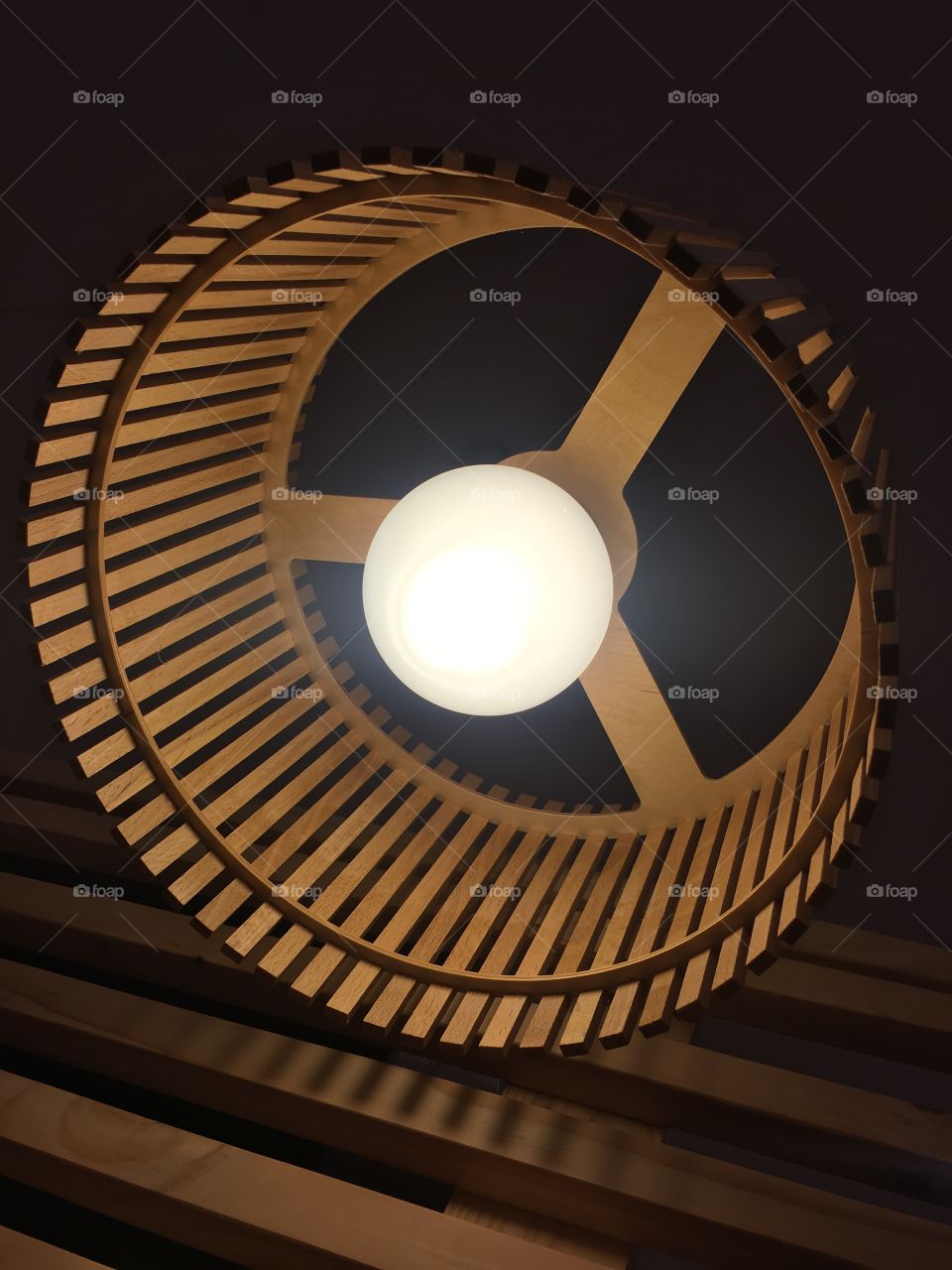 Lightbulb and lampshade perspective shot. Shadows in motion like a spinning wheel.