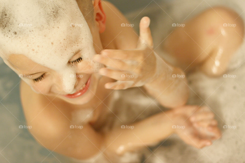 Boy bathing with soap sud in bathroom