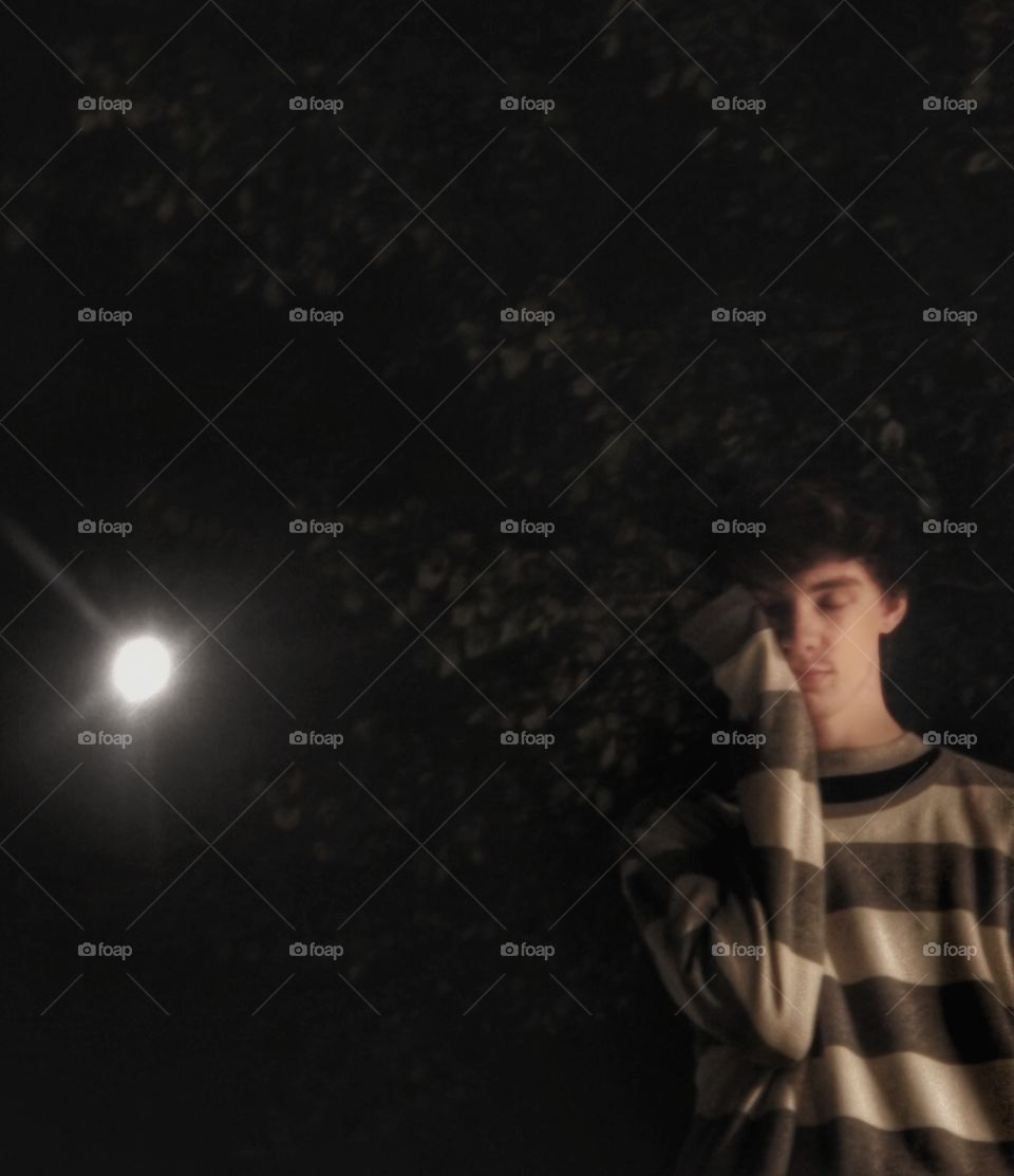 young man at night under moon