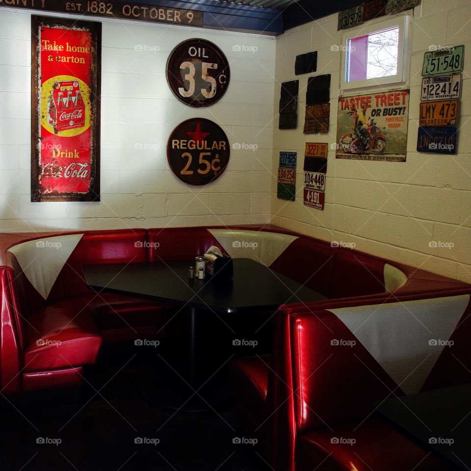 An old fashioned diner advertising its beverage product of Coca Cola with a weathered and worn old sign. 