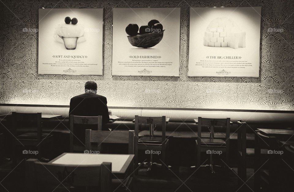 Alone in Wall Street. A businessman eating alone in the wall street.