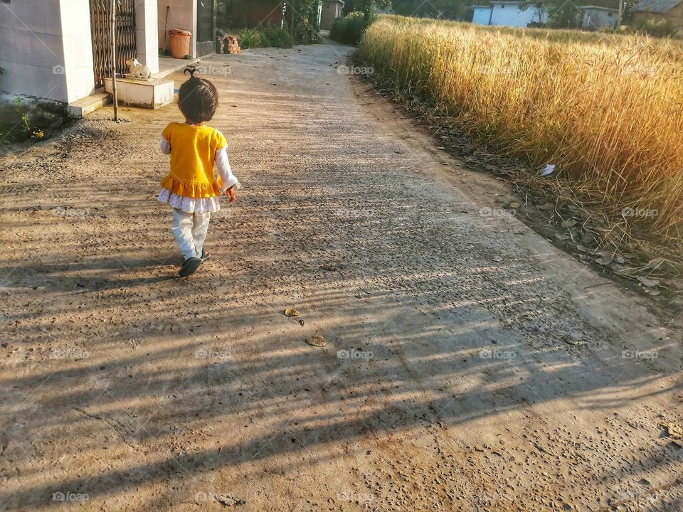 SWEET  BABY GIRL  GOING ON THE WAY  IN VILLAGE AND ENJOYING HER CHILDHOOD.