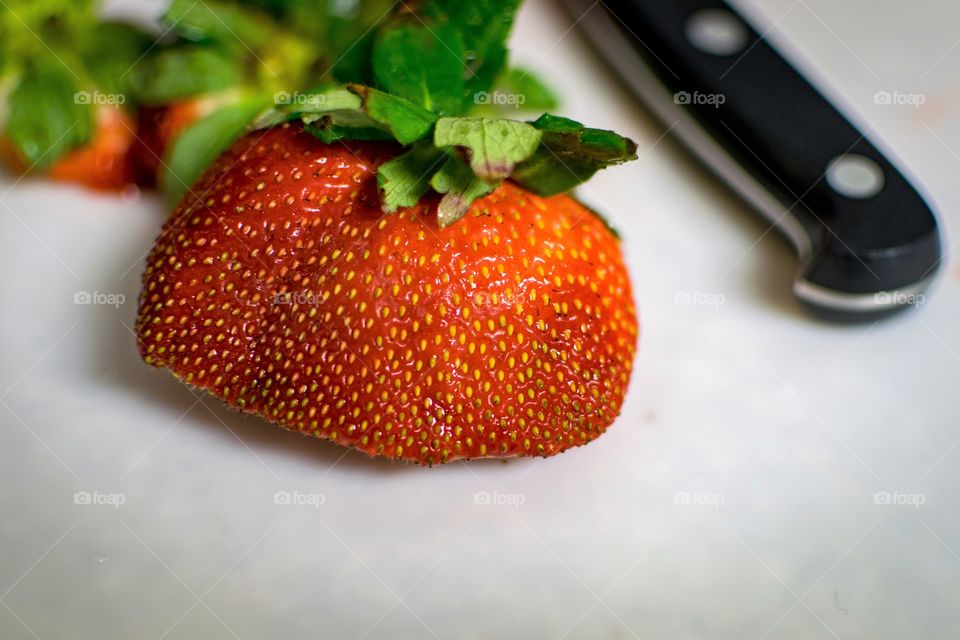 Single Strawberry about to get cut