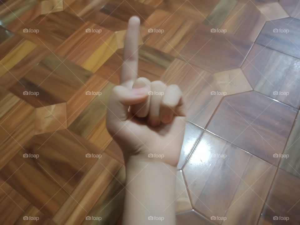 a boy is pointing to the ceiling of his house