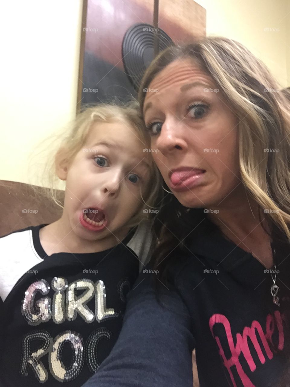 Mother and daughter taking a silly selfie. 