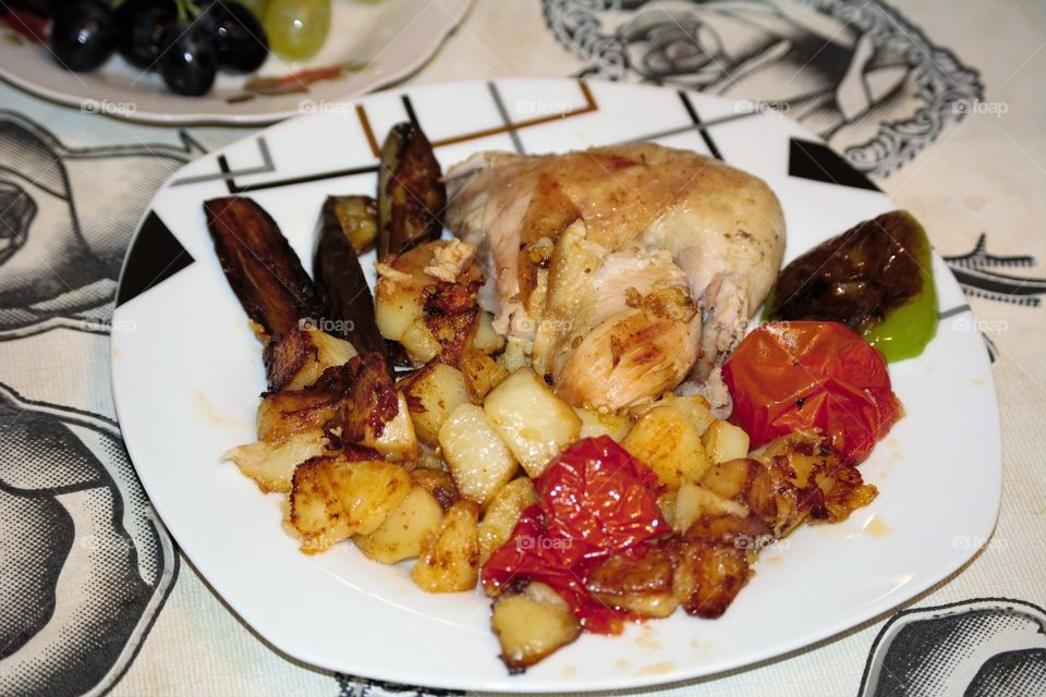 Fried potatoes, chicken, eggplant and tomatoes .