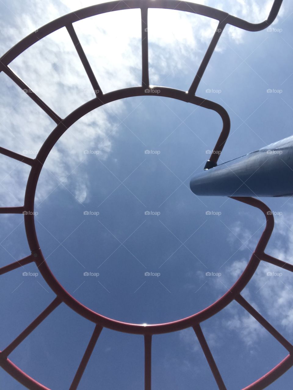 Monkey bars in a park playground with a skyview
