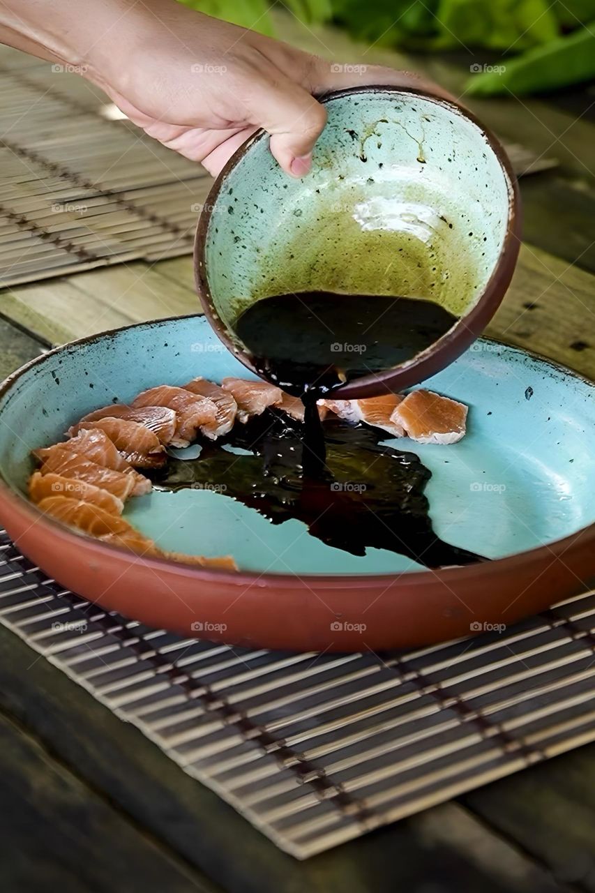 Pouring soy sauce over tuna sushi