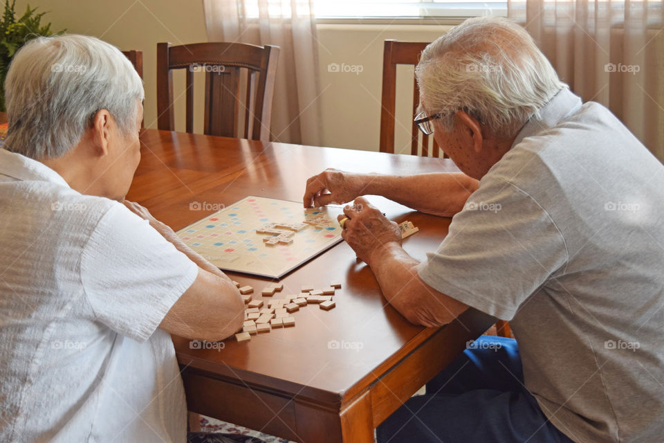 Elderly couple playing Scrabble for mental fitness