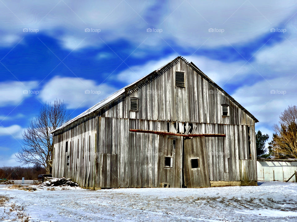 Barn on a winter day in Indiana with snow and a beautiful sky