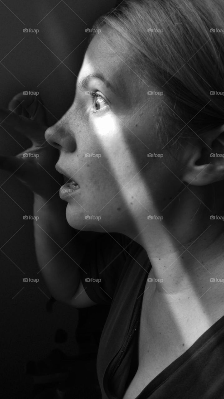 black and white photo of a girl who, in the dark and horrified, watches what is happening in the world