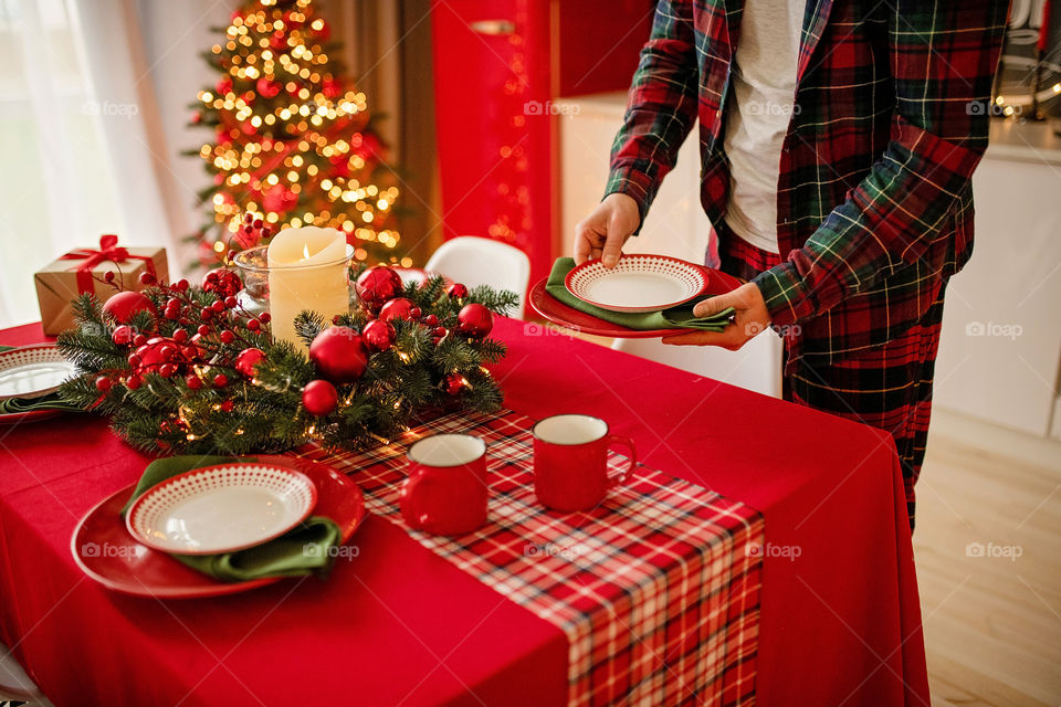 man sets a beautiful decorated winter table for a festive dinner.  Merry Christmas and Happy New Year.