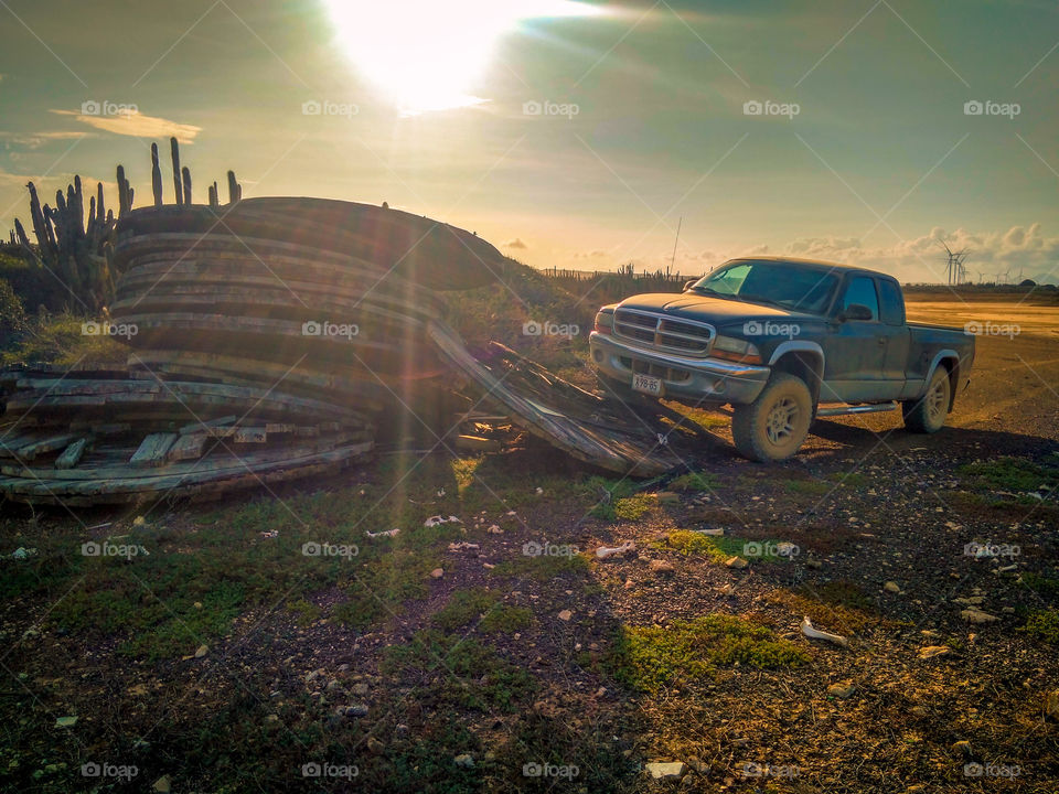 Truck next to some wooden plates out in the desert