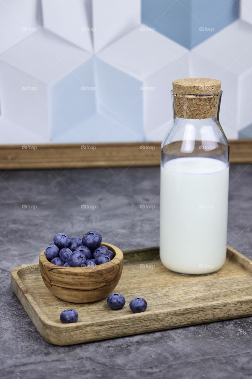 Bottle with milk and blueberries