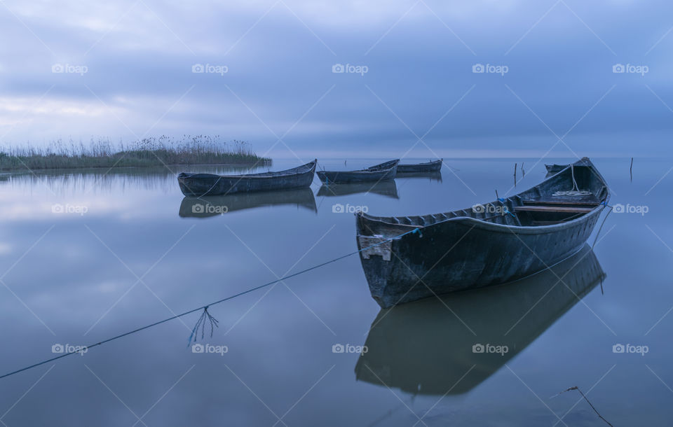 Wooden boat moored on idyllic lake