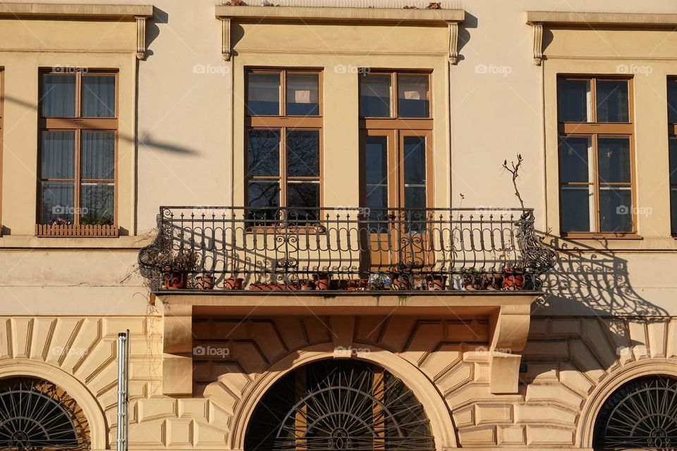 Beautiful spacious balcony with a decorative railing above the entrance of an old building of Lowit's mill in Prague near Palmovka, Czech Republic.