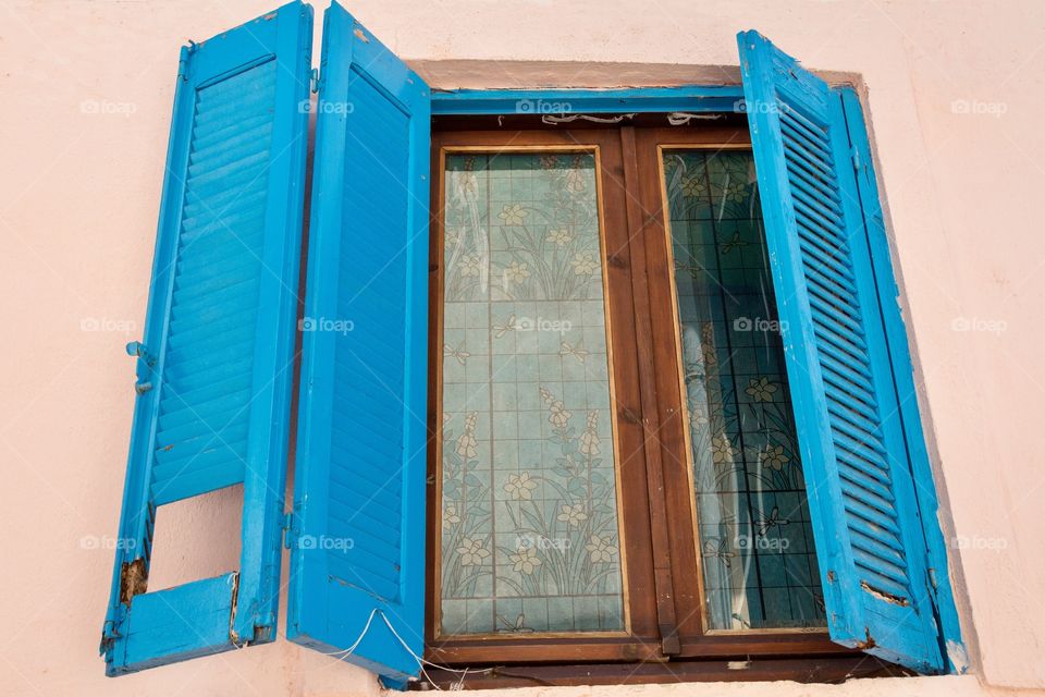 Old wooden window shutters with floral ornaments on glass