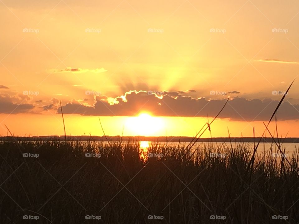 Sun falling out of clouds over Lake Apopka In Winter Garden Florida at Newton Park