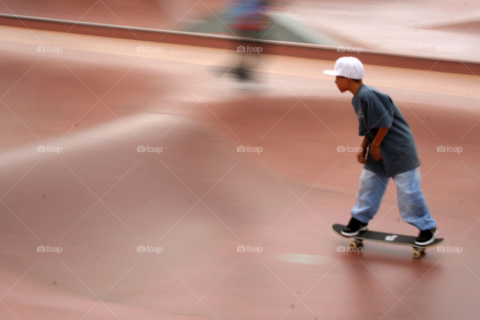 Skating. A boy riding a skateboard at a local skate park