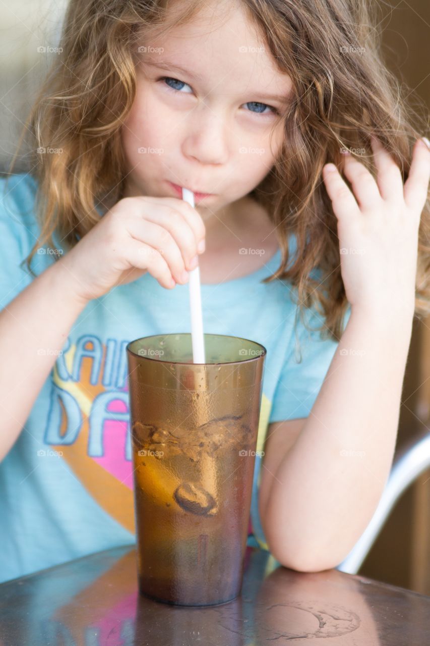 Girl drinking through straw 