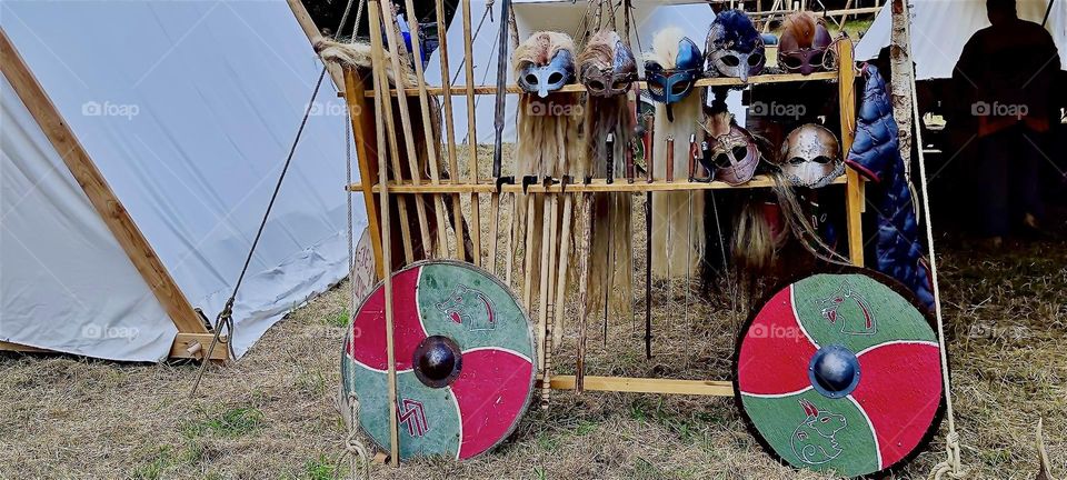 This is a display of arrows, bows, shields and metallic face masks for bow and arrow shooting. It is offered as part of the “Renaissance Festival” in “Ortenburg” in “Bavaria”, Germany near the “Austrian” border. 2023. Hypnotic Productions