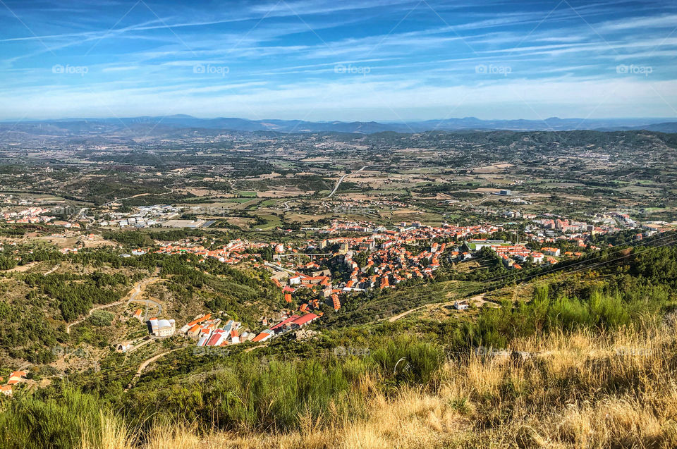 A landscape view looking down at the town of Covilha and beyond to mountains in the far distance