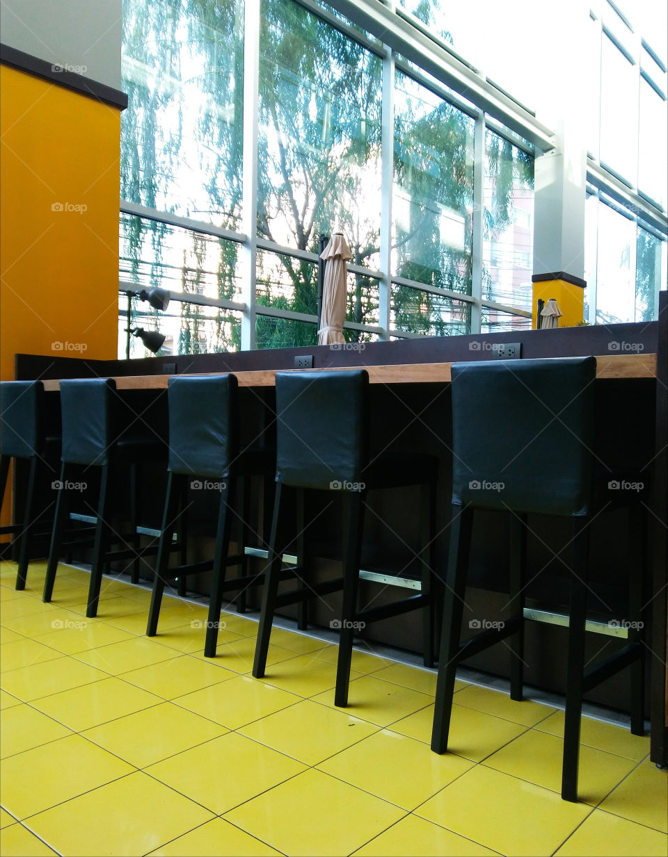 Black high chairs and counter on yellow floor.