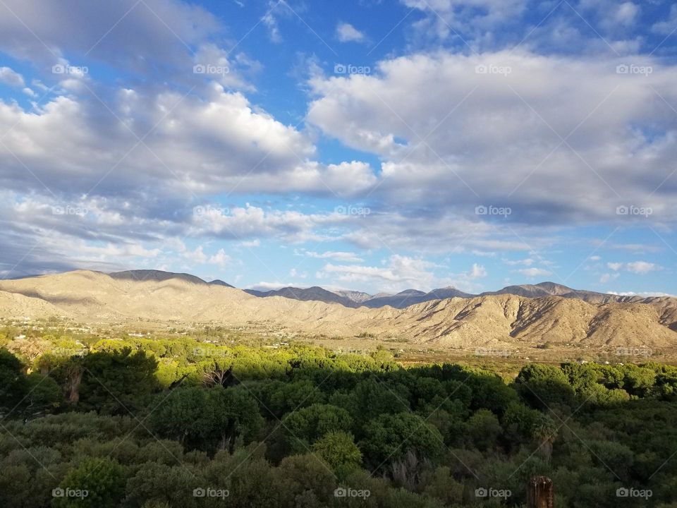 Natural Landscape with clouds, distant hills, and trees.
