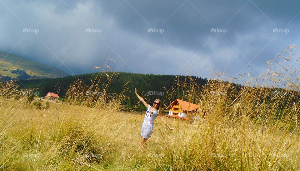 Woman with arms raised standing on meadow