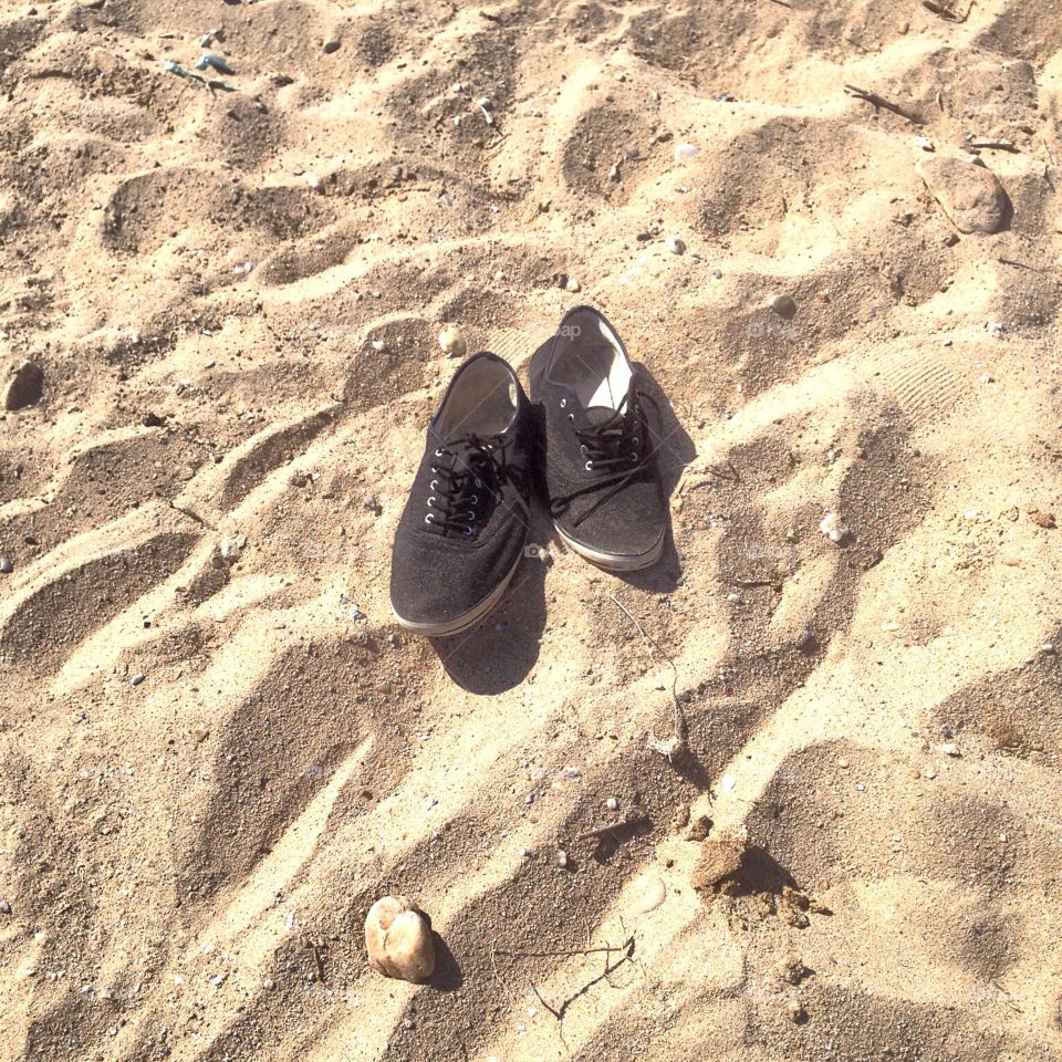 Black shoes in a yellow sand 