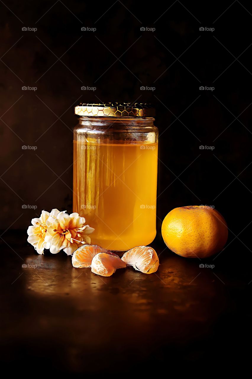 Honey and Orange
Close up of jar of honey with orange fruit and flowers.