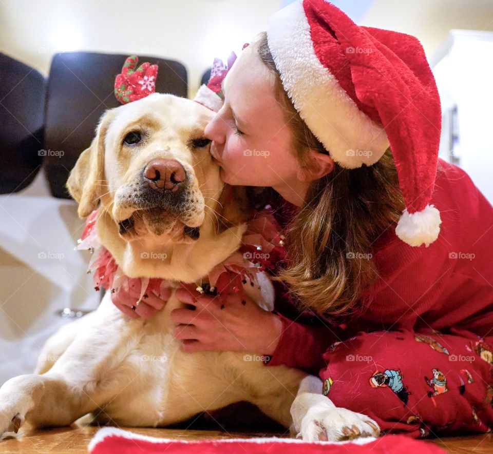 Christmas morning with girl and her yellow Labrador dog