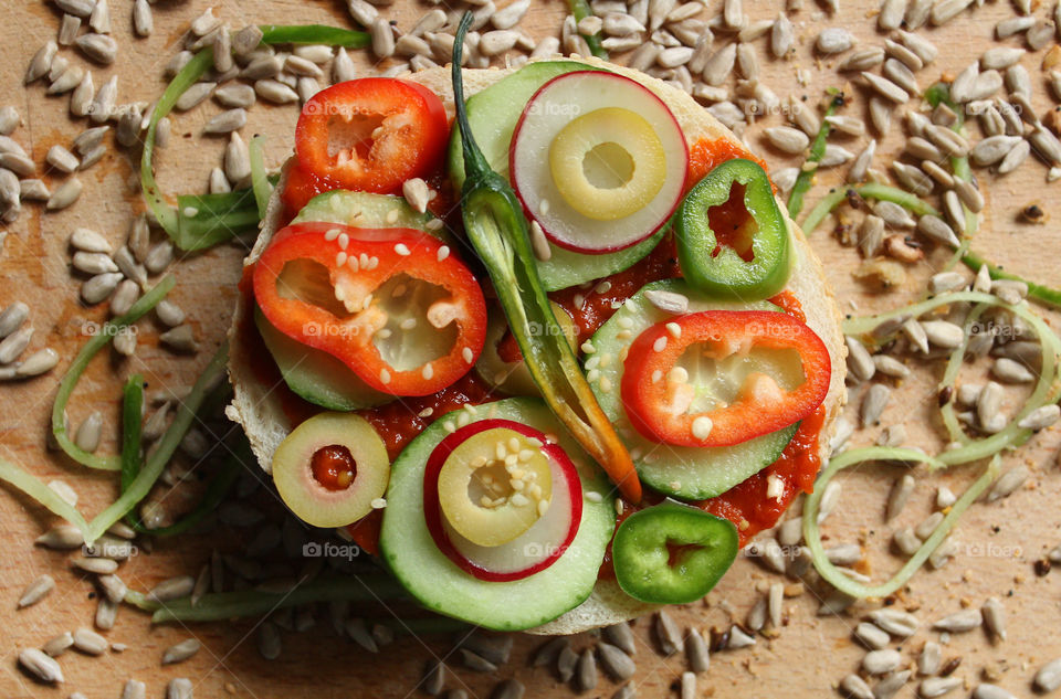 A sandwich with peppers, cucumbers and seeds 1