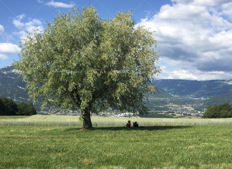 Two people chilling in the magical outside by a tree after first quarantine 